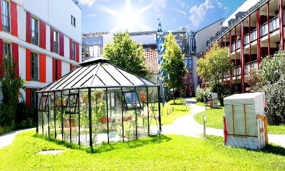 Ein modernes Gebäude mit Glasdach im sonnigen Innenhof des Theresianum 2022, präsentiert von BlueBranch GmbH.